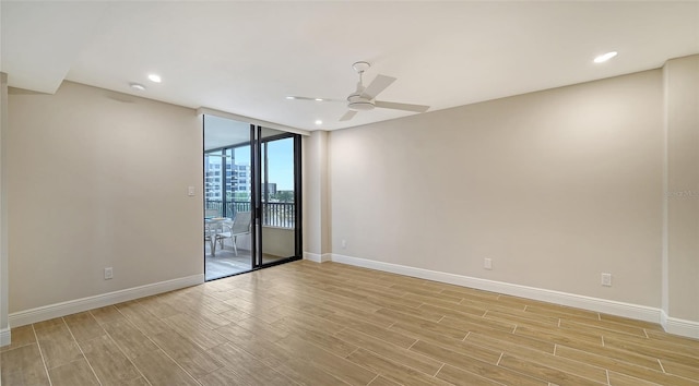 empty room featuring floor to ceiling windows, light wood-type flooring, and ceiling fan