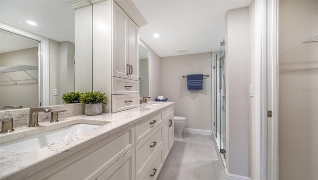 bathroom with vanity, toilet, and a shower with shower door