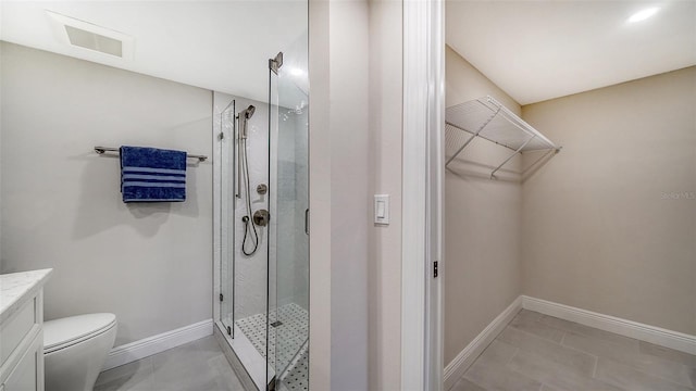 bathroom with tile patterned floors, vanity, toilet, and walk in shower