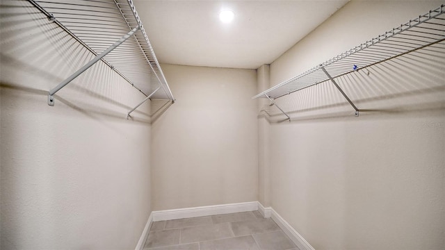 walk in closet with light tile patterned floors