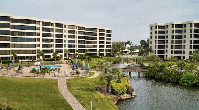 view of property's community with a lawn and a water view