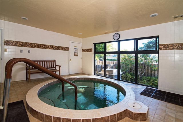 view of pool with an indoor hot tub