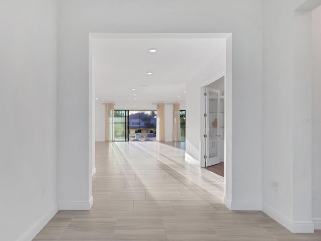 corridor featuring recessed lighting and baseboards