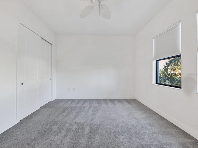 empty room featuring baseboards, a ceiling fan, and carpet flooring