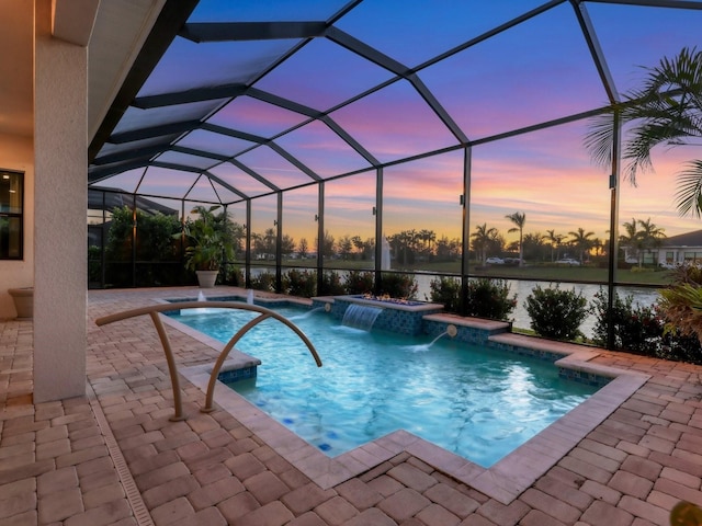pool at dusk featuring a patio area, a lanai, and a hot tub