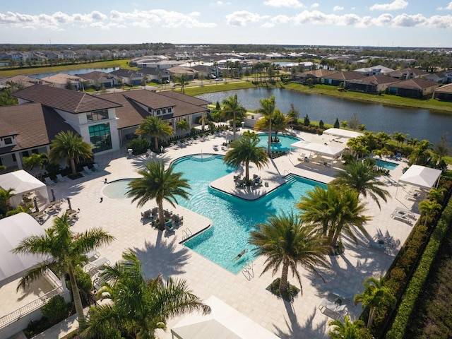 pool with a residential view, a patio area, and a water view