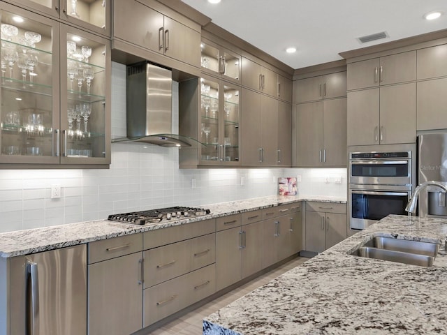 5058 Surfside Cir, Lakewood Ranch, FL 34211 - kitchen with wall chimney exhaust hood, stainless steel appliances, decorative backsplash, light stone countertops, and light wood finished floors