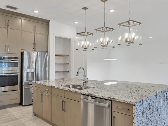 5058 Surfside Cir, Lakewood Ranch, FL 34211 - kitchen featuring appliances with stainless steel finishes, light stone counters, a center island with sink, a chandelier, and recessed lighting