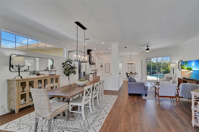 dining area with a textured ceiling, wood-type flooring, and ceiling fan with notable chandelier