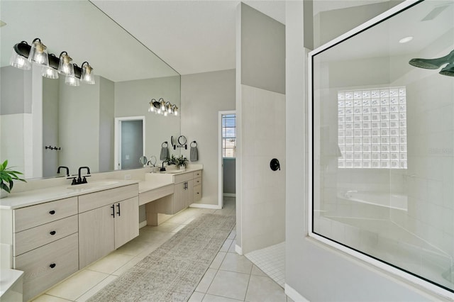 bathroom with tile patterned floors, vanity, and a tile shower