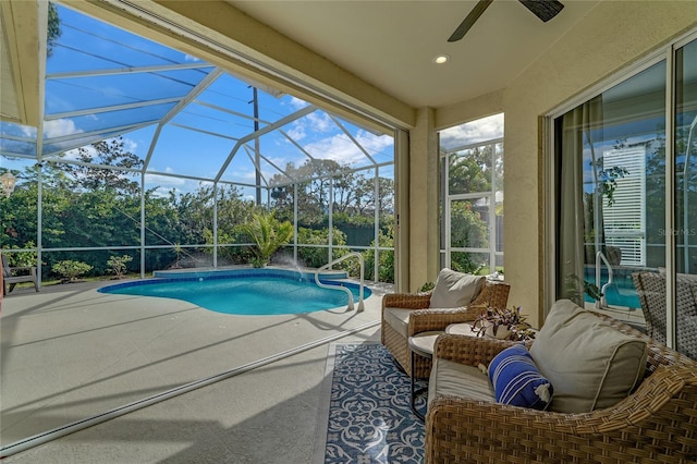 view of swimming pool with ceiling fan, a patio area, and glass enclosure