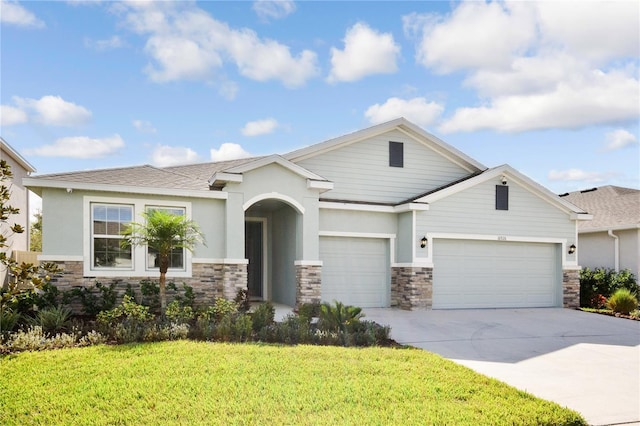 16926 Harvest Moon Way, Bradenton, FL 34211 - view of front of home featuring an attached garage, driveway, a front lawn, stone siding, and stucco siding