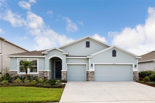 16926 Harvest Moon Way, Bradenton, FL 34211 - view of front facade featuring an attached garage, stone siding, a front lawn, concrete driveway, and stucco siding