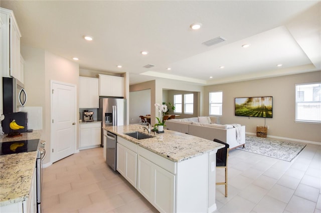 16926 Harvest Moon Way, Bradenton, FL 34211 - kitchen with a sink, stainless steel appliances, a kitchen island with sink, white cabinets, and open floor plan