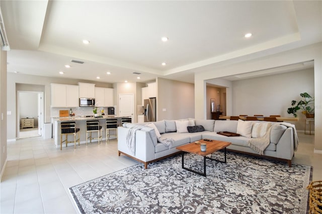 16926 Harvest Moon Way, Bradenton, FL 34211 - living room featuring a raised ceiling, recessed lighting, light tile patterned floors, and baseboards