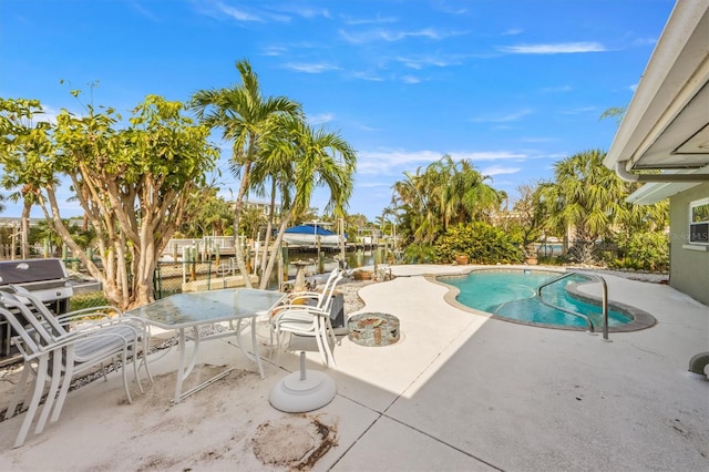 view of swimming pool featuring a patio and a water view