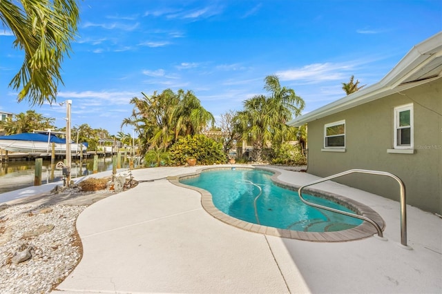 view of swimming pool with a patio area, a dock, and a water view