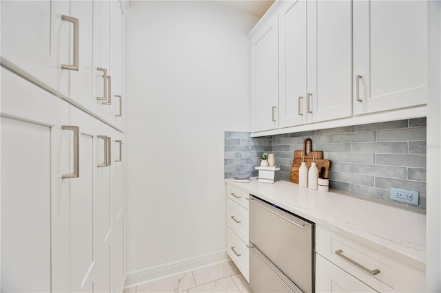 bar featuring tasteful backsplash, light stone countertops, and white cabinets