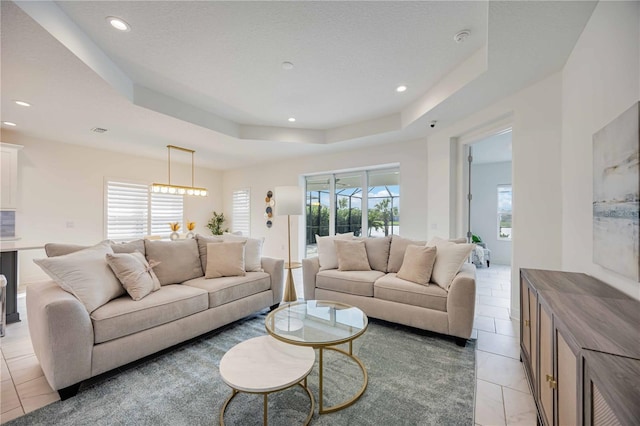 tiled living room with a raised ceiling and plenty of natural light