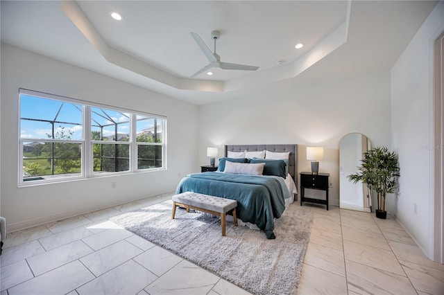 bedroom featuring a raised ceiling and ceiling fan