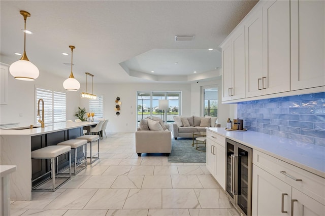 kitchen featuring white cabinets, decorative light fixtures, and plenty of natural light