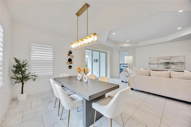 dining space with a raised ceiling