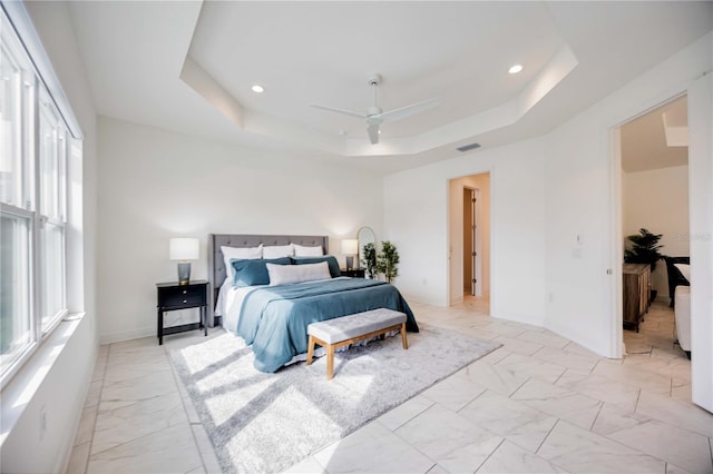 bedroom with a tray ceiling and ceiling fan