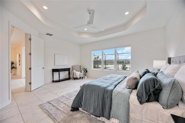 bedroom with a tray ceiling and ceiling fan