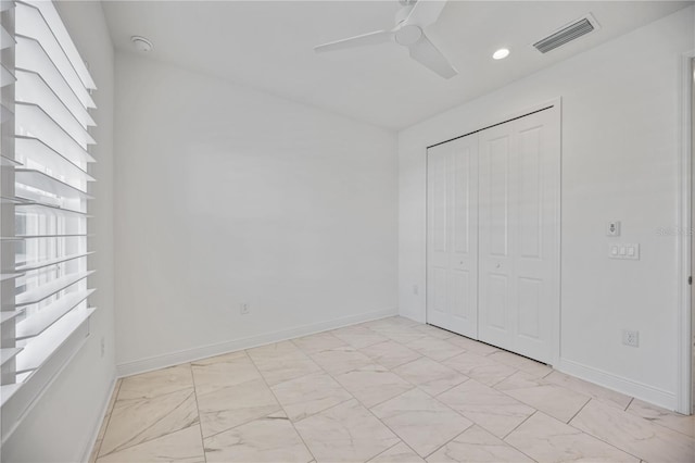 unfurnished bedroom with ceiling fan and a closet