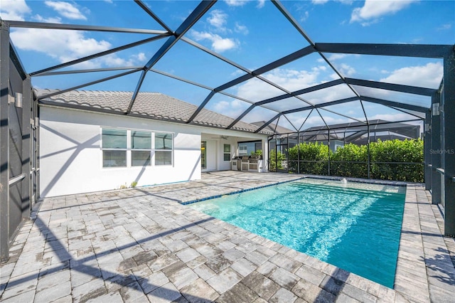 view of pool featuring a patio, ceiling fan, and a lanai