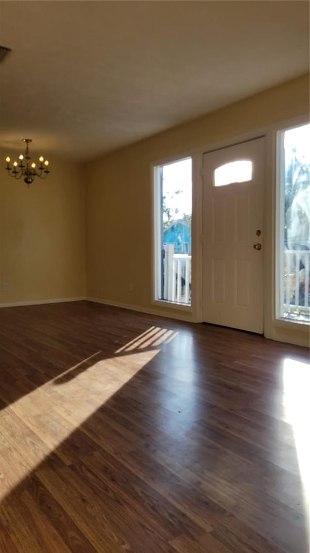 entryway with a chandelier and dark wood-type flooring