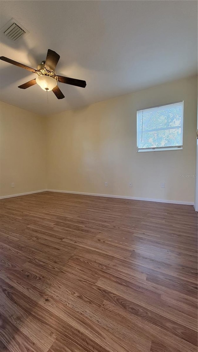 spare room featuring ceiling fan and dark wood-type flooring