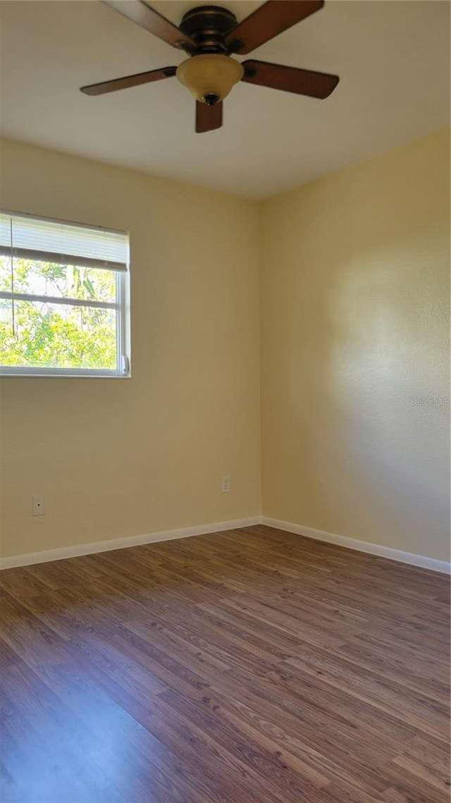 empty room with ceiling fan and dark wood-type flooring