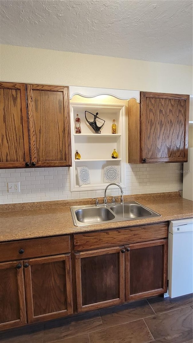 kitchen with dishwasher, decorative backsplash, a textured ceiling, and sink