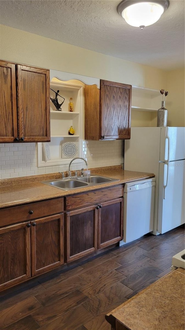 kitchen featuring sink, dark wood-type flooring, a textured ceiling, white appliances, and decorative backsplash