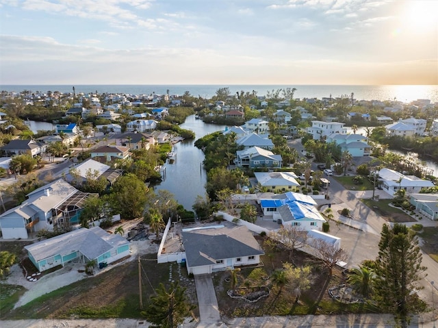 aerial view at dusk featuring a water view