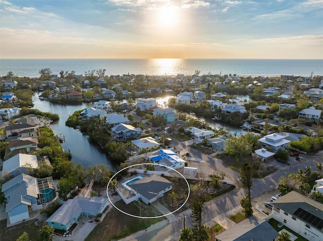 aerial view at dusk featuring a water view