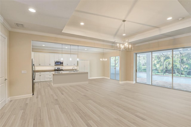 unfurnished living room with light hardwood / wood-style flooring, crown molding, and sink