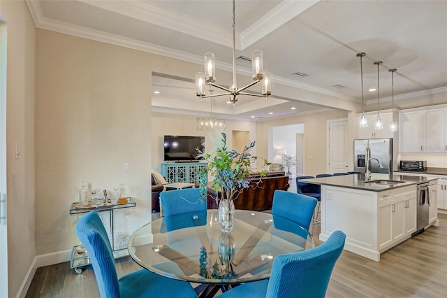 dining room featuring light hardwood / wood-style floors, ornamental molding, and sink