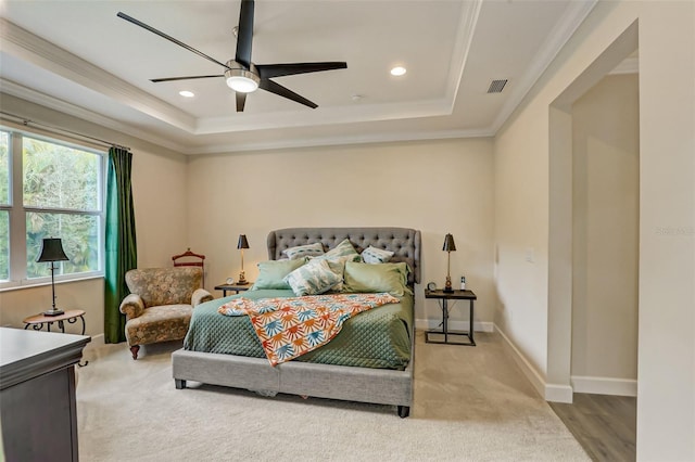 bedroom featuring a tray ceiling, ceiling fan, crown molding, and light colored carpet