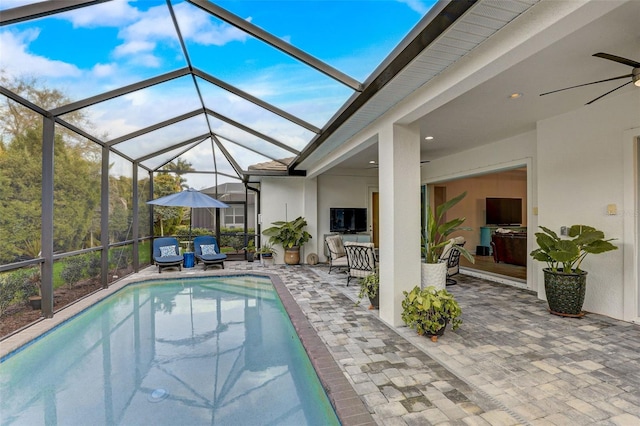 view of pool featuring ceiling fan, a patio area, and glass enclosure