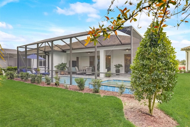 back of property featuring ceiling fan, a patio area, a lanai, and a yard