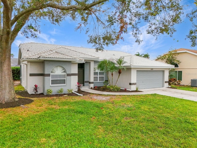 single story home featuring cooling unit, a front yard, and a garage