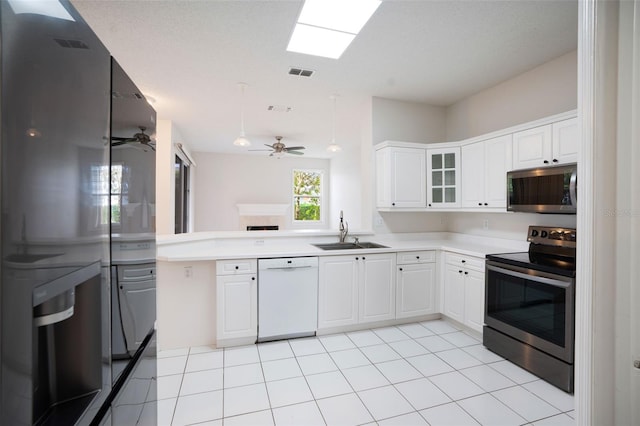 kitchen with light countertops, visible vents, appliances with stainless steel finishes, white cabinets, and a sink