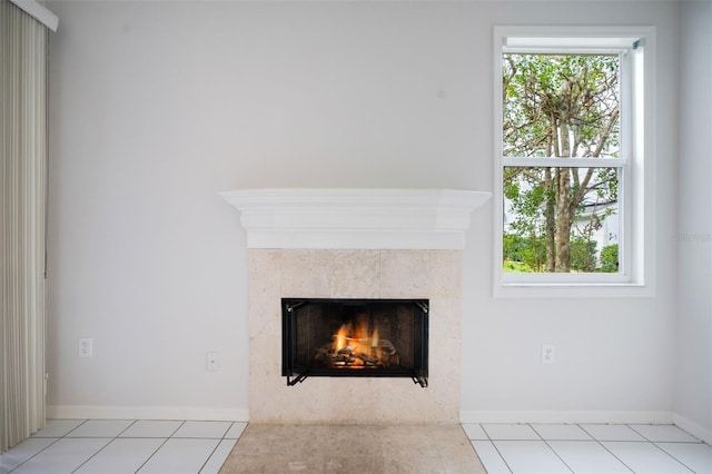 room details featuring baseboards and a tiled fireplace