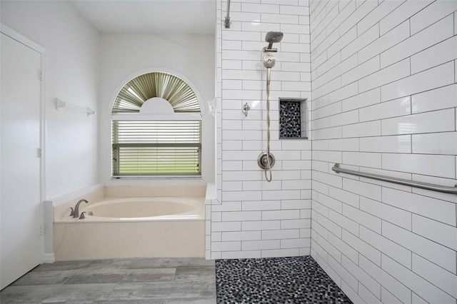 bathroom featuring a garden tub and a tile shower