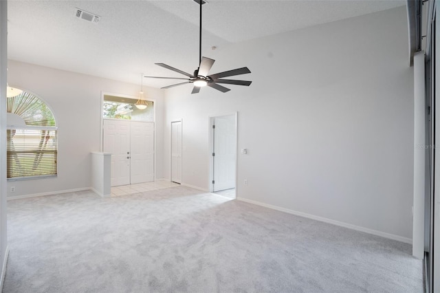 unfurnished bedroom featuring light carpet, baseboards, visible vents, lofted ceiling, and a textured ceiling