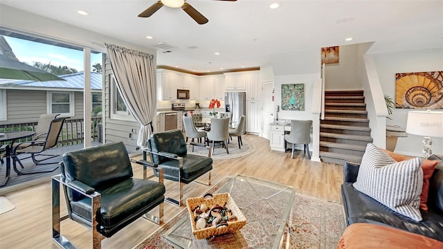 living room featuring ceiling fan and light hardwood / wood-style floors