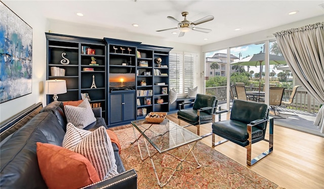 living area featuring hardwood / wood-style floors and ceiling fan