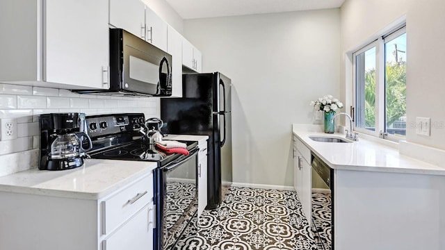 kitchen featuring white cabinetry, sink, light stone counters, backsplash, and black appliances